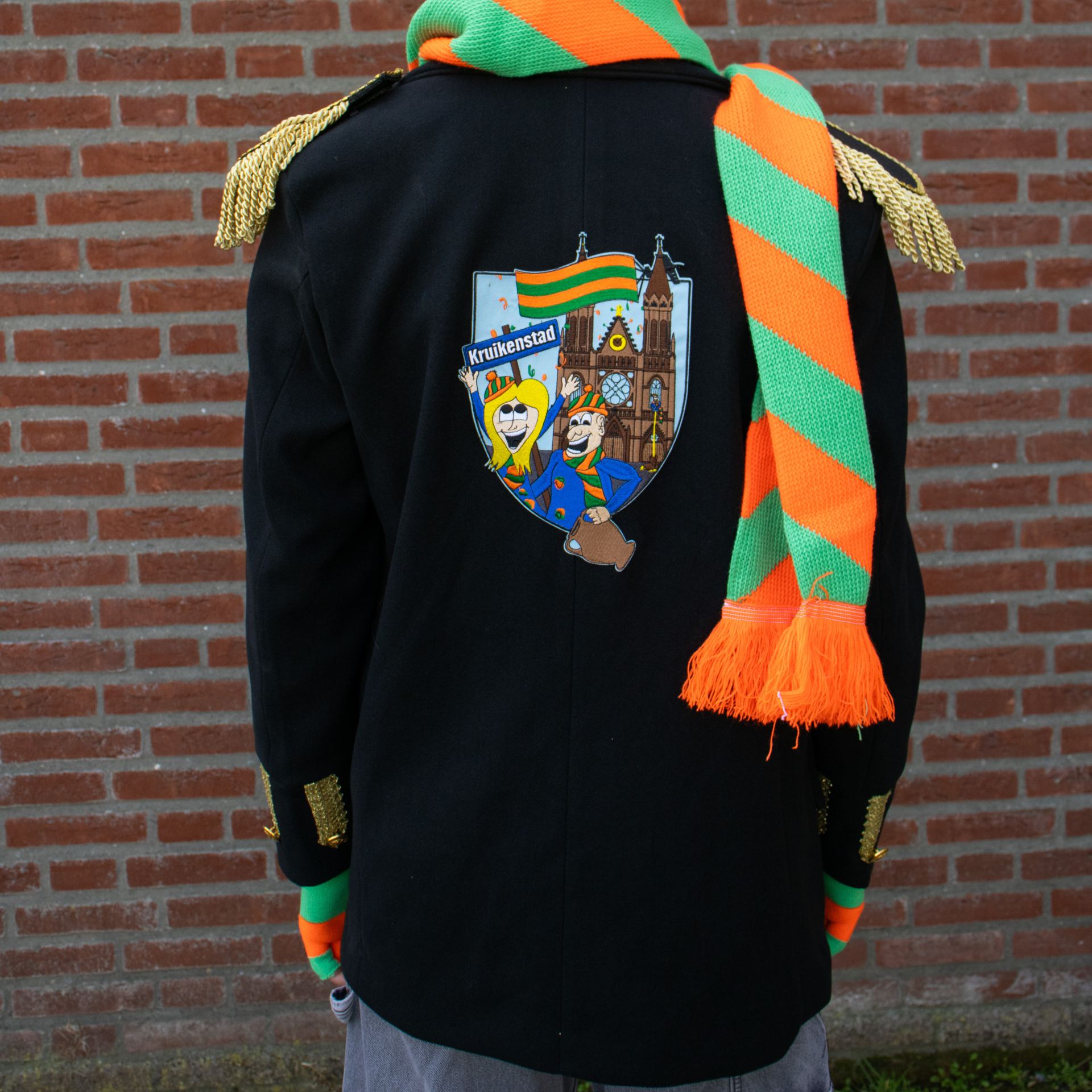 Kruikenstad jasje met emblemen aan